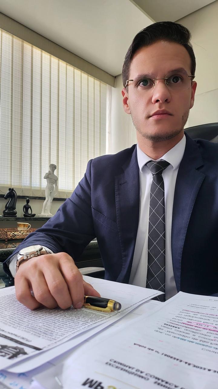 Lucas Ribeiro Arruda analisando documentos no escritório